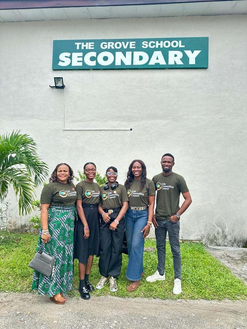 Gilt Counselling Consult team in branded shirts standing in front of The Grove School Secondary sign