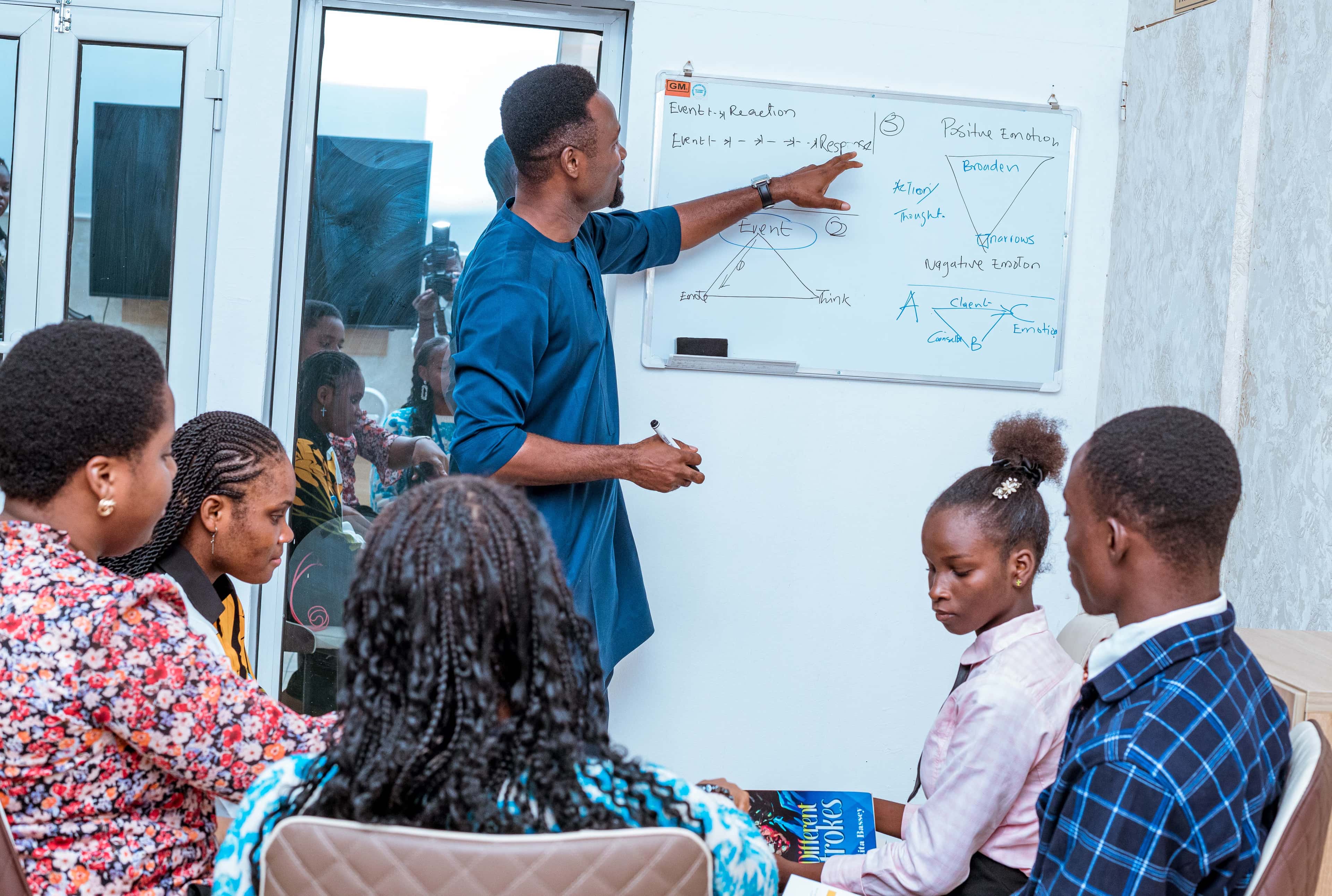 Counsellor teaching young people at a whiteboard session