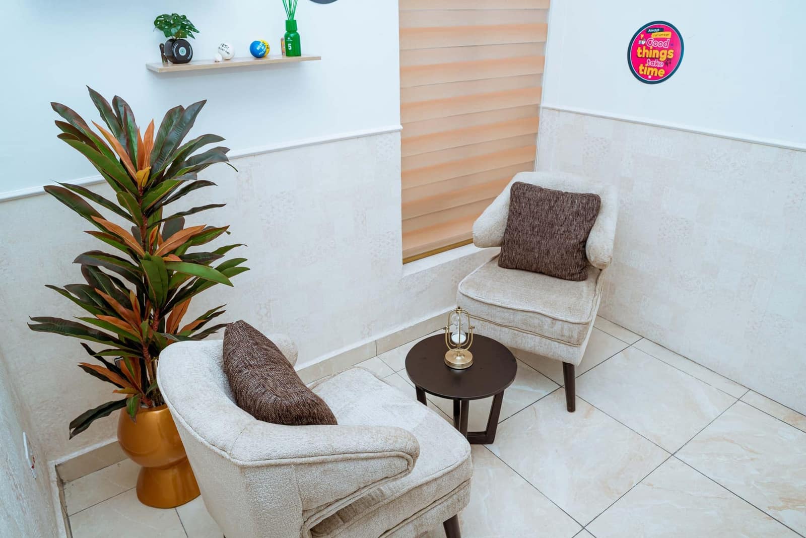 A calm counselling room with two armchairs, a small table, and a plant